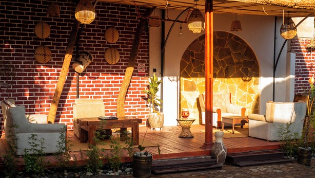 Eine Terrasse mit Backsteinmauern, Gartenmöbeln und Dekorationselementen.