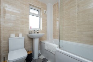 Un baño con inodoro, lavamanos y bañera.