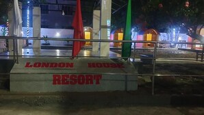 Señal de 'LONDON HOUSE RESORT' con una barandilla metálica al frente.
