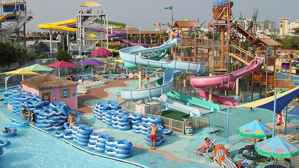 Ein Wasserpark mit mehreren Rutschen und aufblasbaren Flößen.