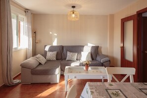 Una sala de estar con un sofá, una mesa de centro y una puerta.