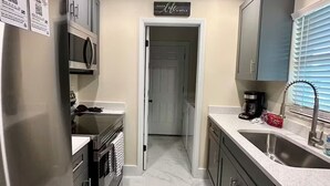 A modern kitchen with stainless steel appliances, a marble floor, and a sign that reads "Keep Life Simple". - The 98 House Minutes from WEC, OBS, FAST & HITS. Located off of W HWY 40! (Ocala)