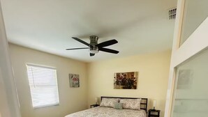 A bedroom with a bed, a ceiling fan, a window with blinds, and a painting on the wall. - The 98 House Minutes from WEC, OBS, FAST & HITS. Located off of W HWY 40! (Ocala)