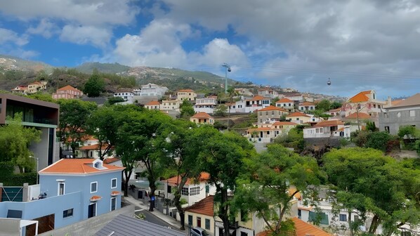 Un barrio residencial en una ladera, con casas, árboles y un teleférico.