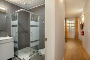 A modern bathroom with a glass shower enclosure, a white sink, and a toilet. - Apartment 'Refúgio Na Cidade 104' with Wi-Fi (Funchal)