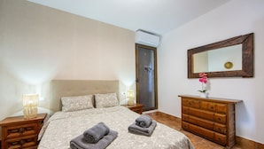 A bedroom with a bed, a dresser, a mirror, and a nightstand with a lamp. - 'Guest Apartment with Private Pool, Wi-Fi and Air Conditioning' (Roquetas de Mar)