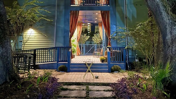 Un bâtiment à deux étages doté d’un balcon et d’une terrasse en bois.
