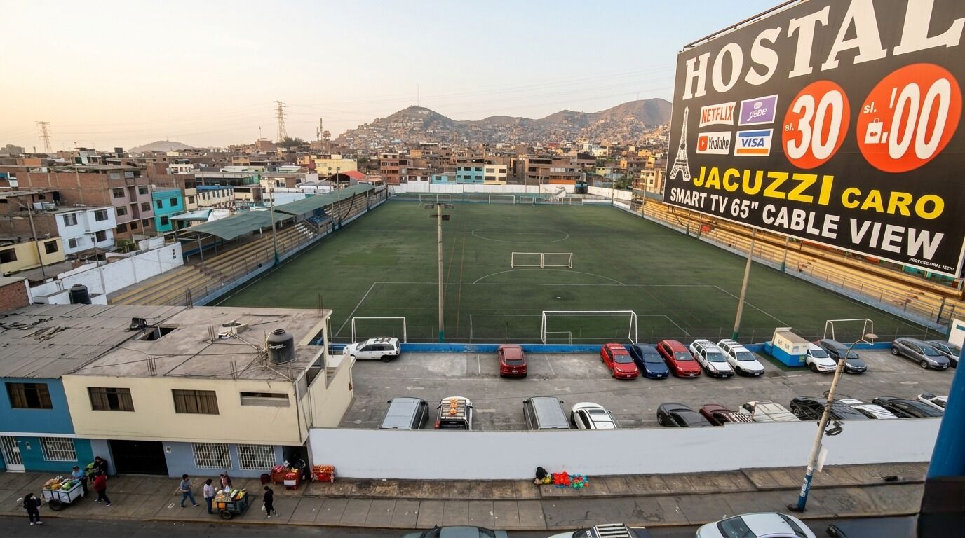 Un campo de fútbol con un gran cartel publicitario de un albergue.