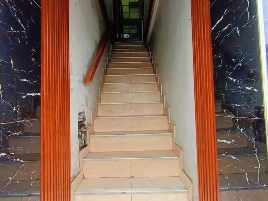 A staircase with beige steps leading to a dark interior.