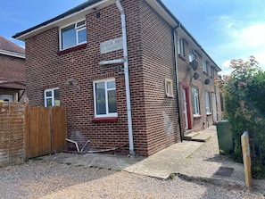 A two-story brick building with a sign indicating 'DERSINGHAM CLOSE'. - Modern 3-Bed | Home Near QA Hospital | Sleeps 7 (Cosham)
