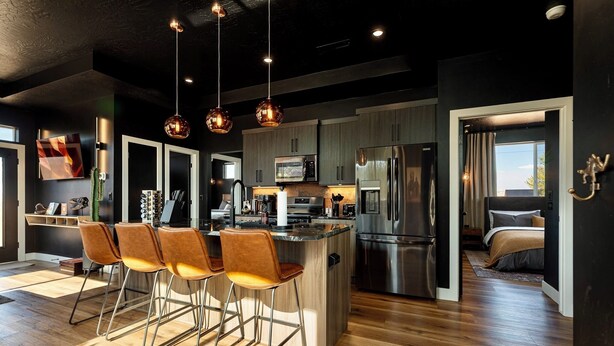 A modern kitchen with a central island, stainless steel appliances, and pendant lighting.