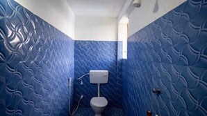 Une salle de bain avec des murs bleus à texture et des toilettes blanches.