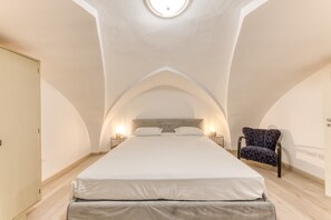 Een slaapkamer met een groot bed, een stoel en een dakraam.