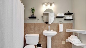 Et moderne badeværelse med toilet, håndvask og håndklædestænger.