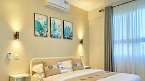 Een hotelkamer met een bed, nachtkastjes en een wandairconditioner.