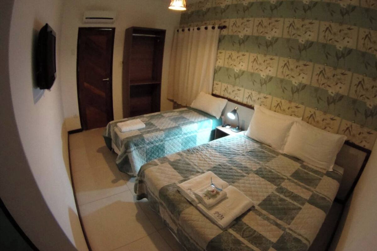 Une chambre avec deux lits, une armoire, un bureau et une table de chevet.