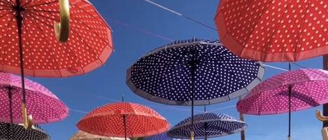 A wooden deck with colorful umbrellas overhead.