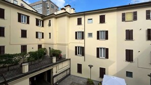 Un edificio residencial de varios pisos con balcones, ventanas y cielo despejado.