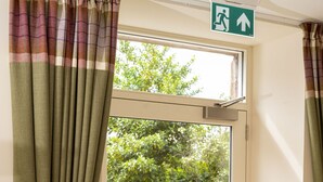 Una stanza con una porta scorrevole in vetro che dà su un patio esterno con tavolo e sedie.