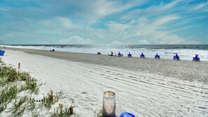 Ein Strand mit Sand, Wellen und blauem Himmel.