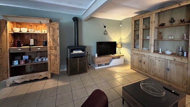 Un salon chaleureux avec une cheminée, des meubles en bois, un téléviseur et un canapé.