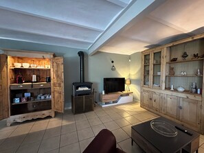 Un salon chaleureux avec une cheminée, des meubles en bois, un téléviseur et un canapé.