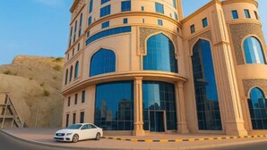 A tall, beige building with multiple windows and a curved facade. - Al Hashmeih Tower Hotel Makkah (Makkah)