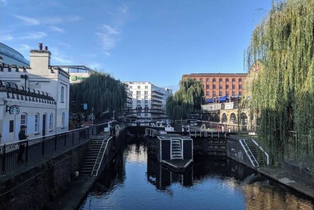A canal with buildings on either side, a bridge, and a staircase leading down to the water.