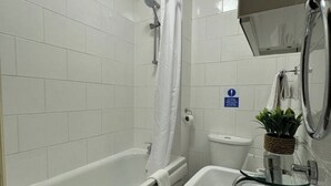 A bathroom with a bathtub, a shower, a toilet, and a sink.