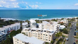 Uma área residencial costeira com edifícios altos, uma praia e uma vista clara do oceano.