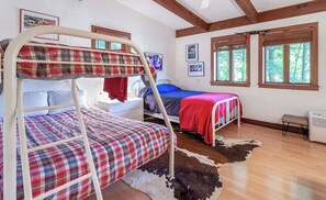 A room with two bunk beds, a cowhide rug, wooden floors, and framed pictures on the walls. - Charming Mid - Century home in the lovely Palisades Park gated community. (Covert)