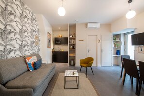 Una sala moderna con un sofá, una mesa de centro y un comedor con sillas.