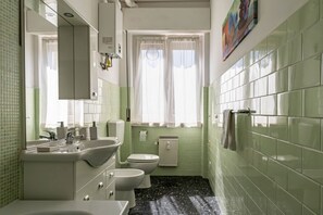 A bathroom with a sink, toilet, and mirror.