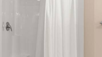 Ein Badezimmer mit einer weißen Badewanne, einer Duschvorhang und einem Wandarmaturen.