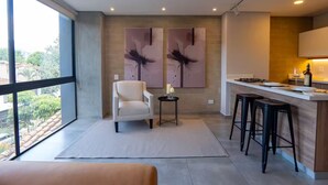 A modern kitchen with a bar area, large windows, and abstract wall art. - Comfort and style in Medellin 301 (Medellín)