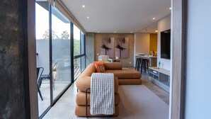A modern living room with a sofa, a TV, and a dining area. - Comfort and style in Medellin 301 (Medellín)