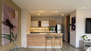 A modern kitchen with a central island, bar stools, and a dining area. - Perfect home in Medellín 501 (Medellín)