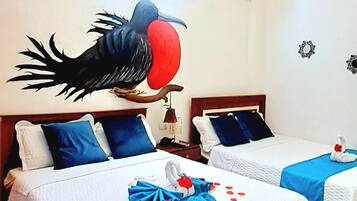 A hotel room with two beds, white bedding, a red balloon, and a swan decoration.