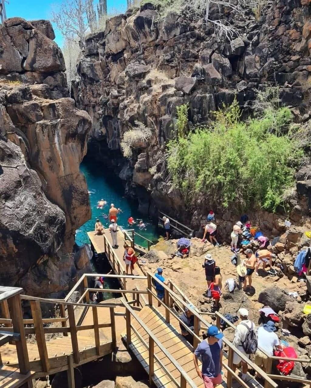 Un cañón rocoso con una plataforma de madera y una poza de agua.