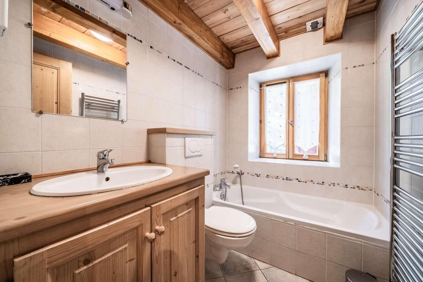 Ein Badezimmer mit Holzausstattung, einem Waschbecken, einer Toilette und einer Badewanne.
