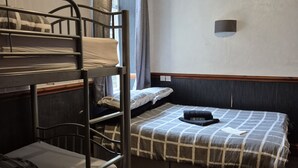 A bunk bed room with a window, a wall-mounted light, and a carpeted floor. - Pine Lodge Hotel (Blackpool)