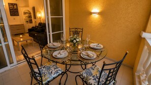 A dining area with a round glass table set for four, surrounded by chairs with floral upholstery. - Studio cabin center Holiday village Cap Estérel (Saint-Raphaël)