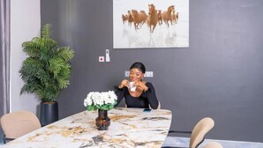 Une salle de conférence avec une table en marbre, une plante en pot et un tableau représentant des chevaux accroché au mur.