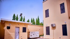 A building with a flat roof, a door, and a window. - Rext  Apartment  (Abuja)
