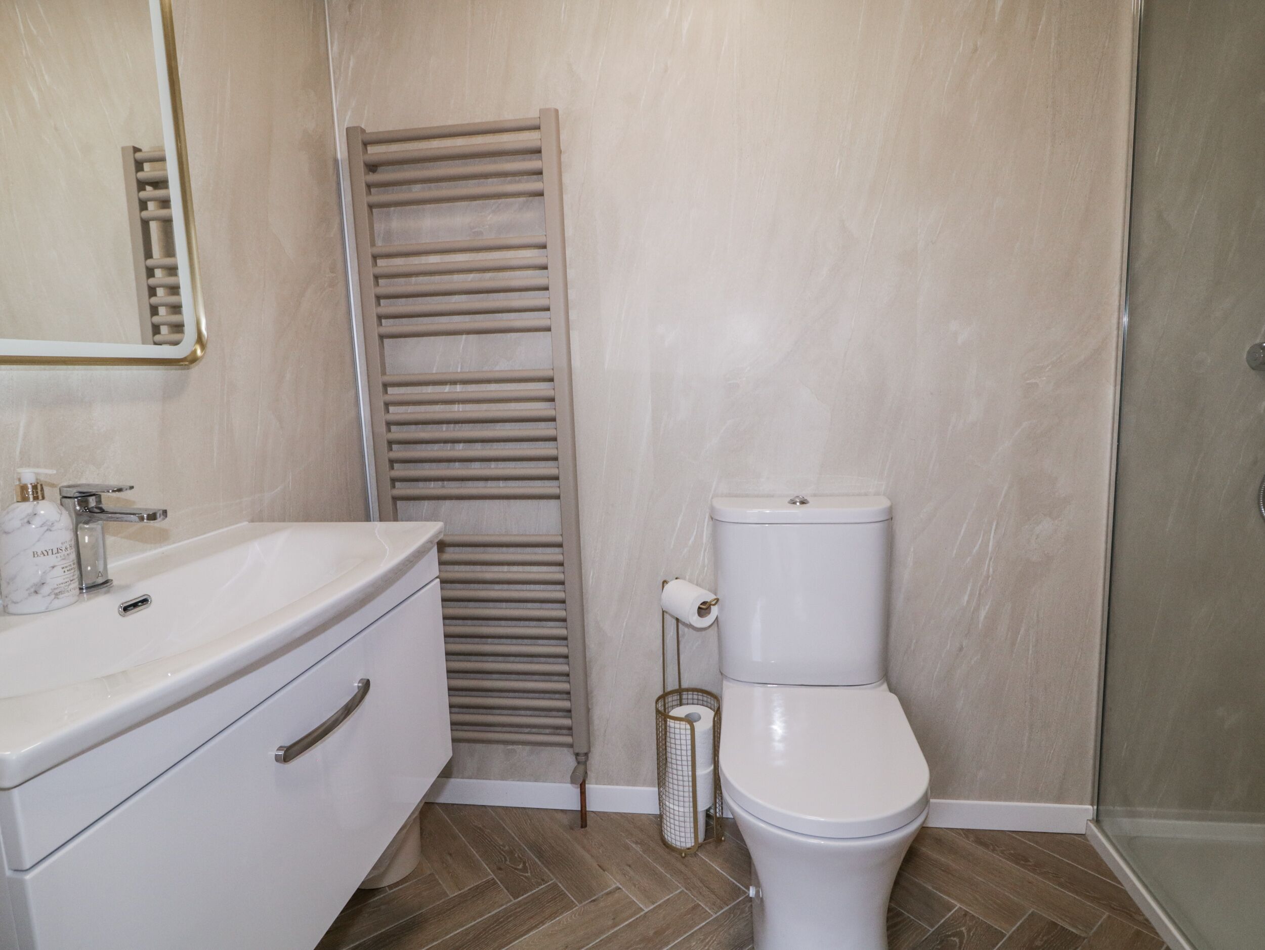 A bathroom with a white sink, a toilet, and a towel rack.