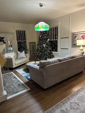 A living room with a Christmas tree, a sofa, a coffee table, and a hanging lamp. - The Nashville - Bed & Breakfast (Hurricane Mills)