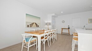 Una cocina moderna con armarios blancos, encimera de madera y un lavaplatos empotrado.