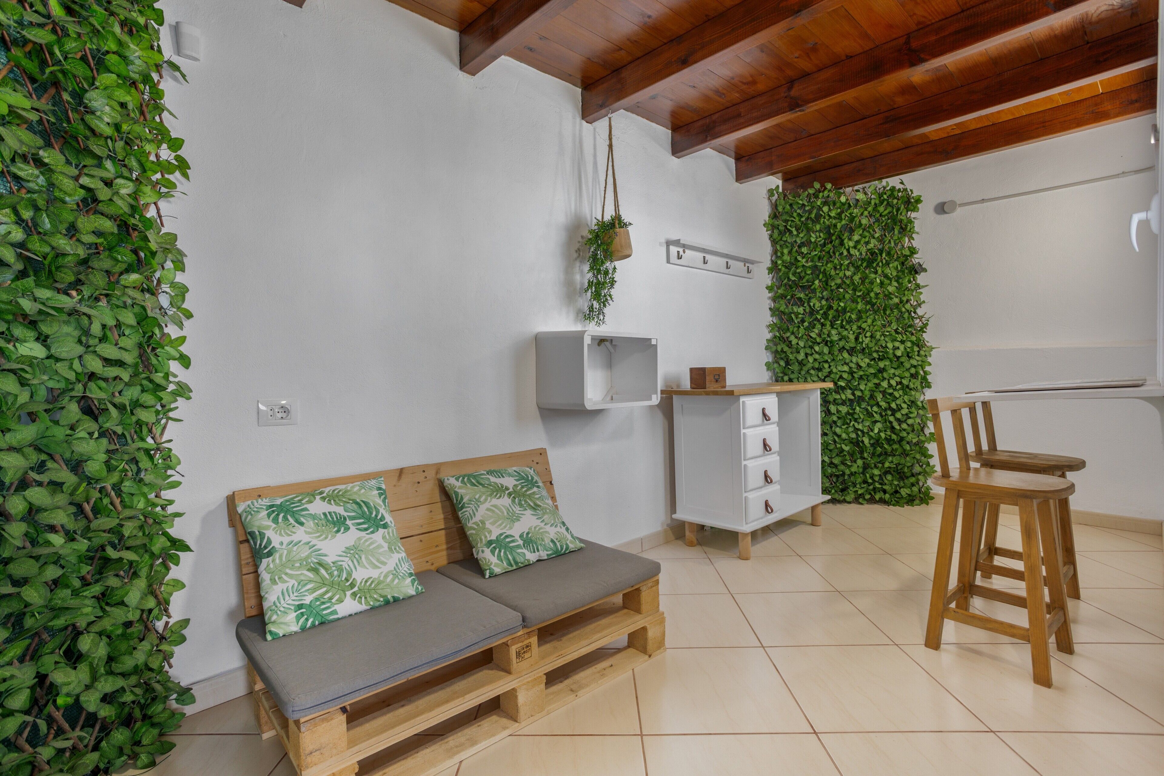 Een kamer met een houten bank, een witte kast en een groene wand.