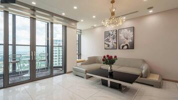 Deluxe-lejlighed - 4 soveværelser - ikke-ryger - byudsigt | Opholdsområde | 16-tommers tv med kabelkanaler, bøger