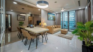 A modern living room with a dining area, large windows, and a view of the city. - The Landmark 81 Deluxe Apartment Suite (Ho Chi Minh City)